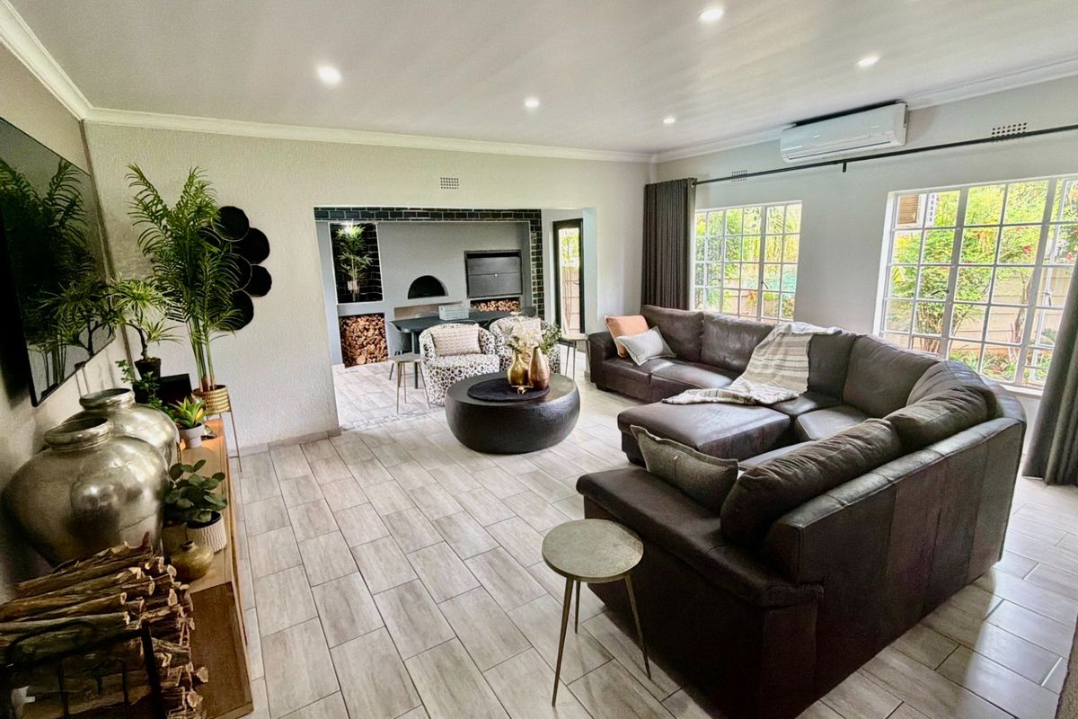 Spacious living room featuring tiled flooring, recessed lighting, a split-system air conditioner, and an integrated fireplace area with a built-in pizza oven.