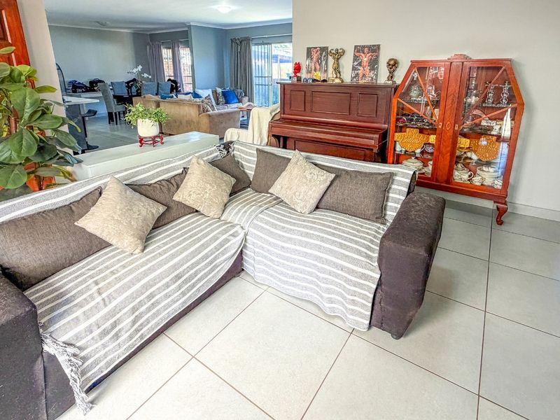 Spacious open-plan living area featuring neutral tiled flooring and direct access to the outdoor space through sliding glass doors.