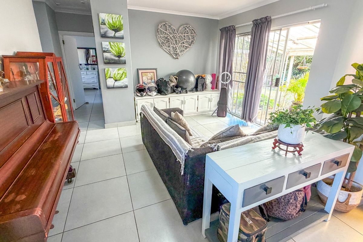 A living room featuring tiled flooring, built-in cabinetry, and a sliding glass door providing access to the outdoor area.