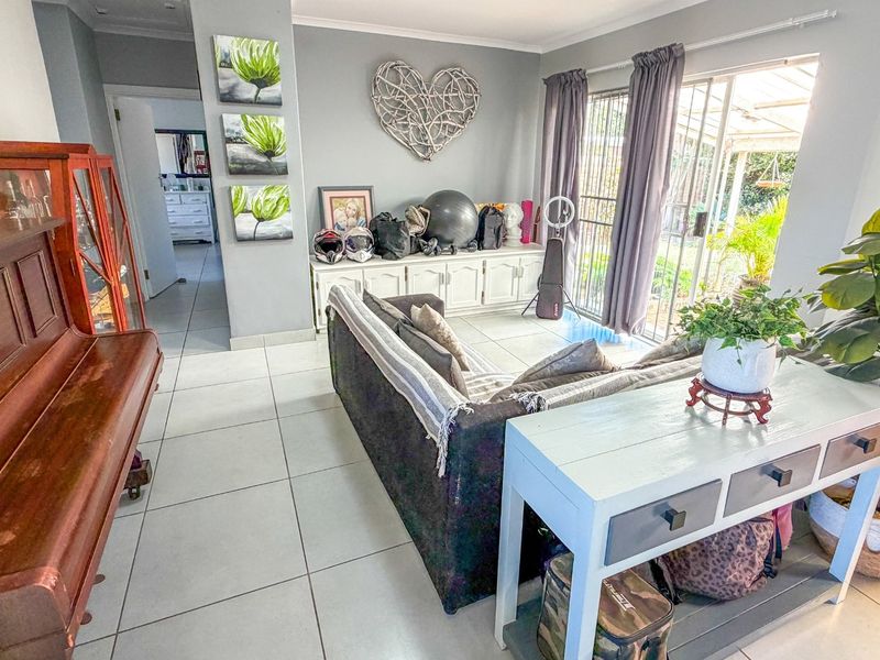 A living room featuring tiled flooring, built-in cabinetry, and a sliding glass door providing access to the outdoor area.