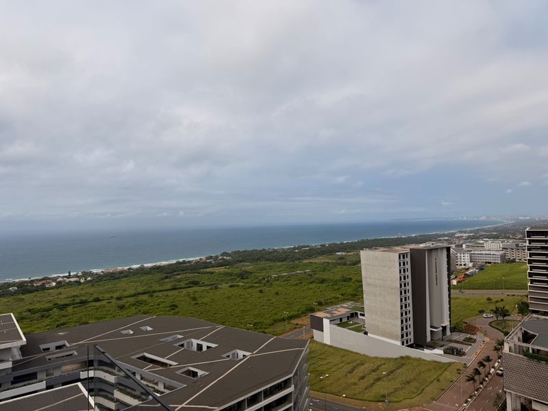 Elevated coastal view overlooking the surrounding landscape, nearby residential developments, and the ocean horizon.