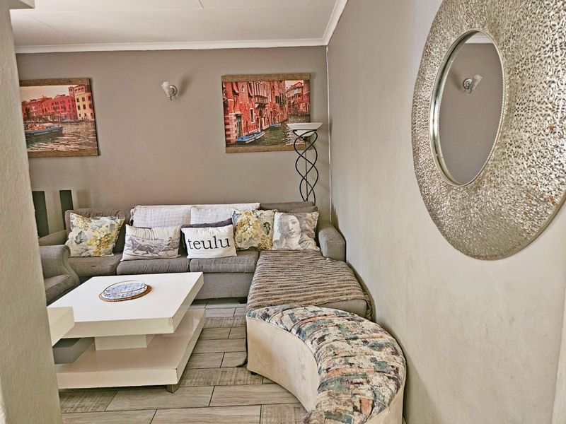 A comfortable living room featuring tiled flooring and wall-mounted lighting fixtures, providing a functional and inviting space for relaxation.