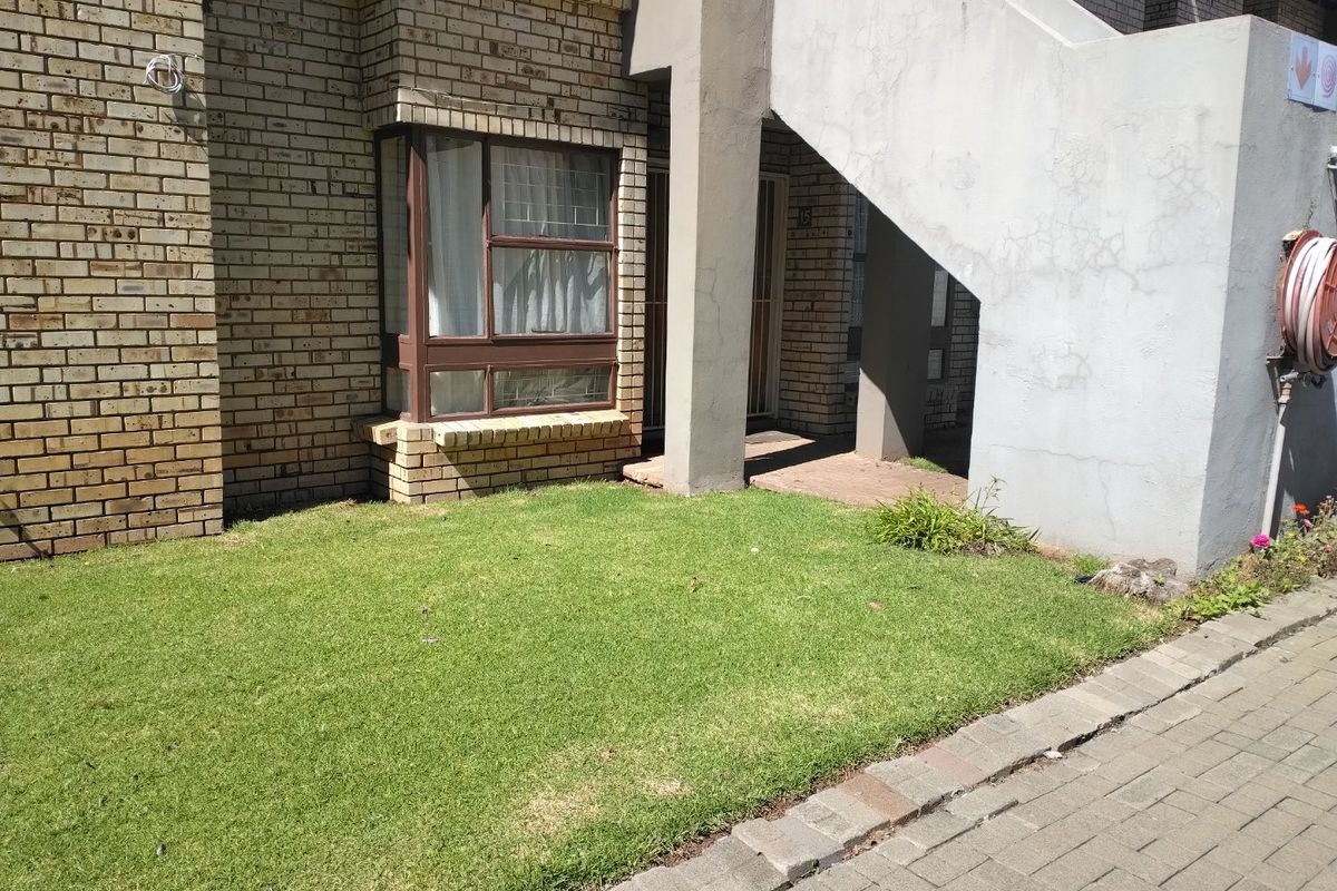 Front exterior view of an apartment unit featuring face brick walls, a bay window, and a concrete staircase leading to the entrance.