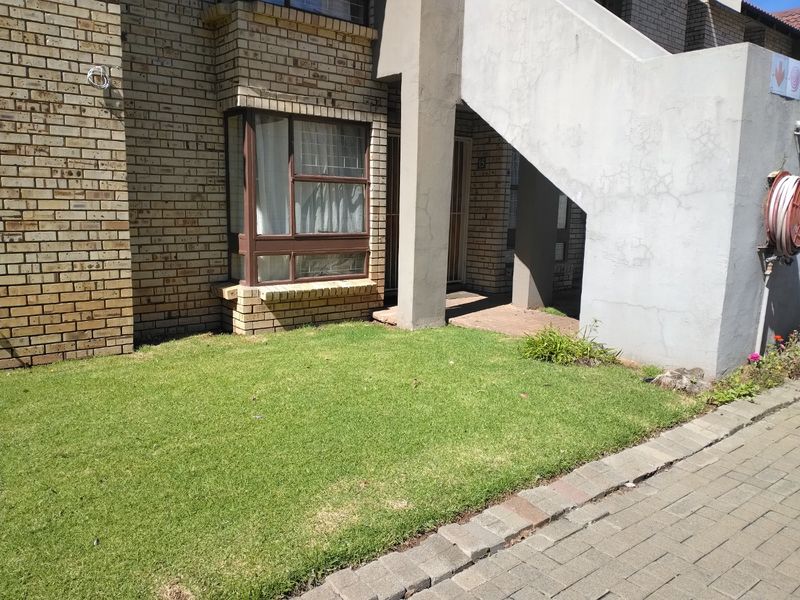 Front exterior view of an apartment unit featuring face brick walls, a bay window, and a concrete staircase leading to the entrance.