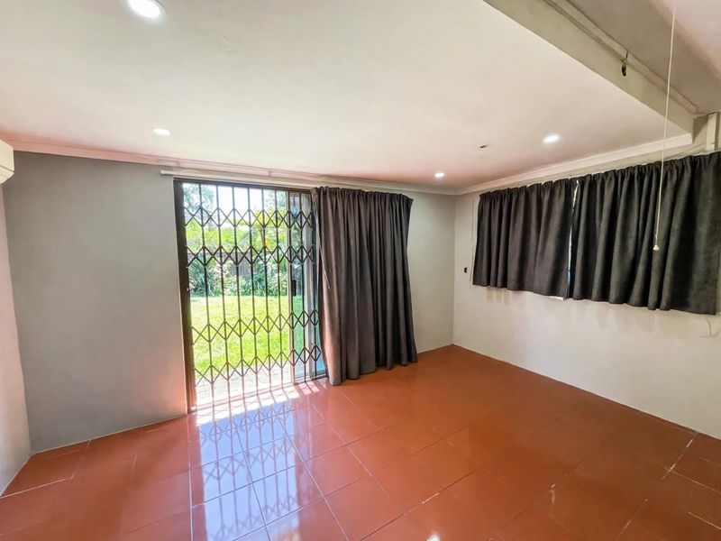 An empty living room featuring ceramic tile flooring, recessed lighting, an air conditioning unit, and a sliding glass door with a security gate.