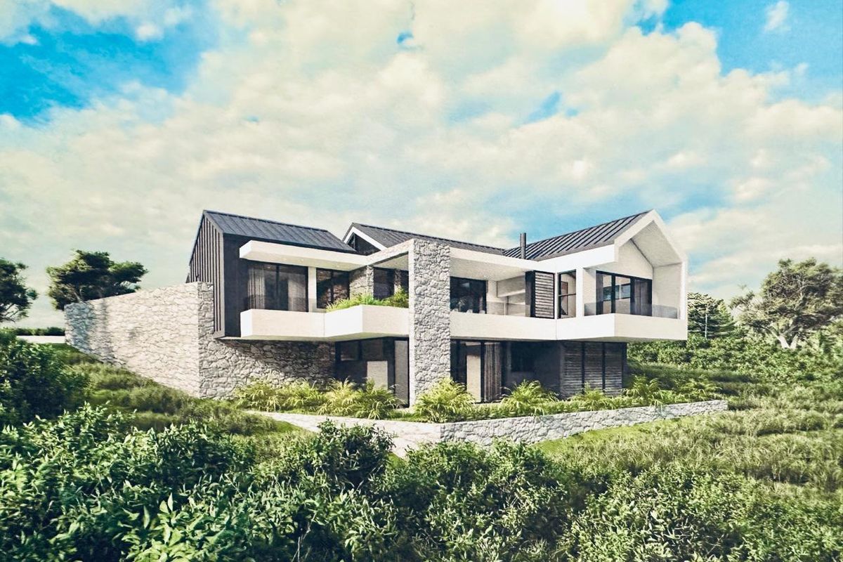 A modern architectural design featuring stone cladding, metal roofing, and expansive balconies, set within a natural landscape.