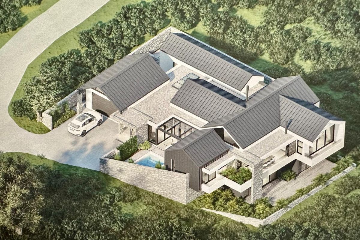An aerial perspective of a modern residential property featuring stone cladding, metal roofing, a private swimming pool, and integrated garage space.