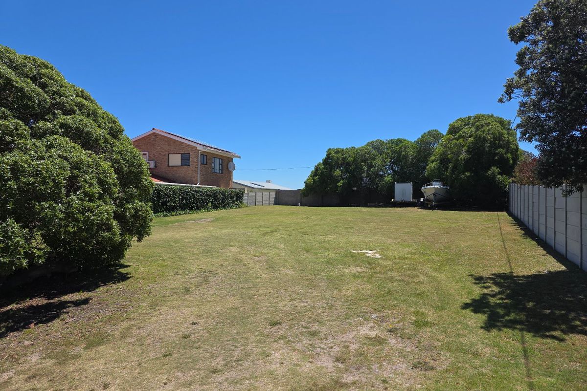 A spacious, level residential plot featuring a well-maintained lawn and secure precast concrete boundary walls, offering a clear space for future development.