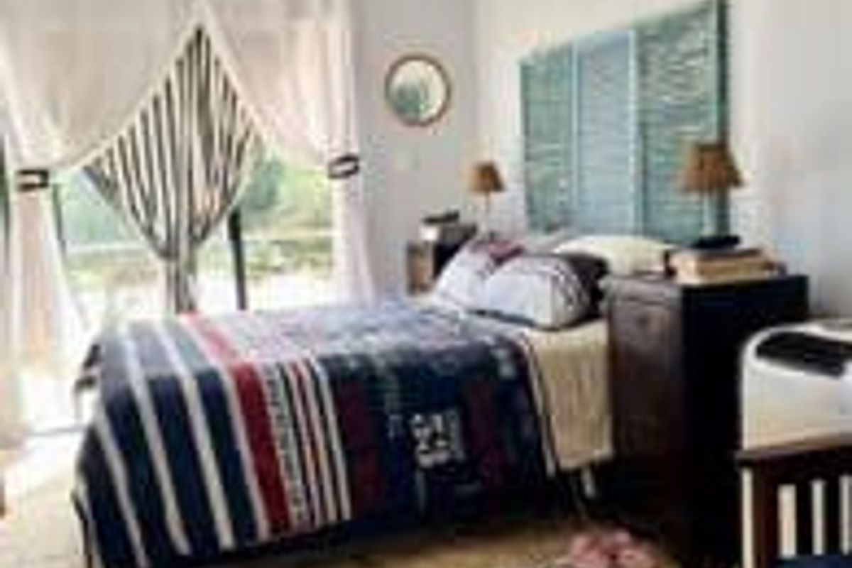A bedroom featuring tiled flooring and a sliding glass door providing natural light and access to the exterior.