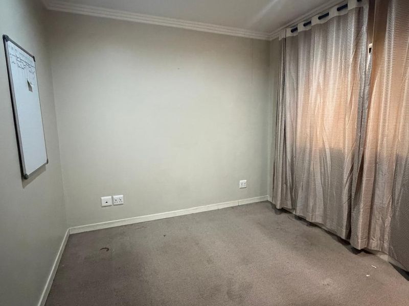An empty bedroom featuring neutral walls, recessed downlighting, and carpet flooring, providing a blank canvas for personalization.