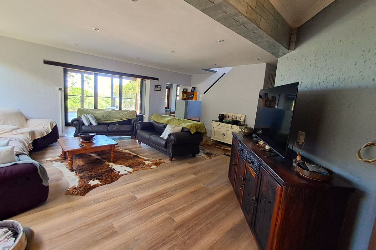 Spacious living room featuring laminate flooring, recessed lighting, and large sliding glass doors that provide natural light and access to the outdoors.