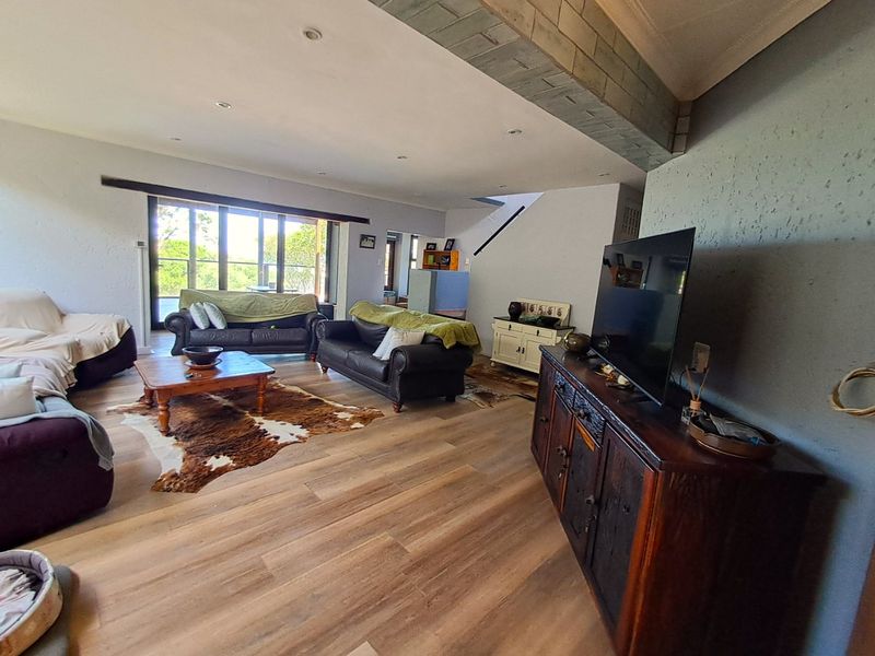 Spacious living room featuring laminate flooring, recessed lighting, and large sliding glass doors that provide natural light and access to the outdoors.