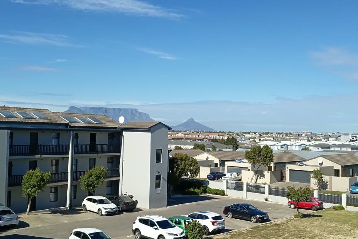Elevated view overlooking the apartment complex parking area with Table Mountain visible in the distance.