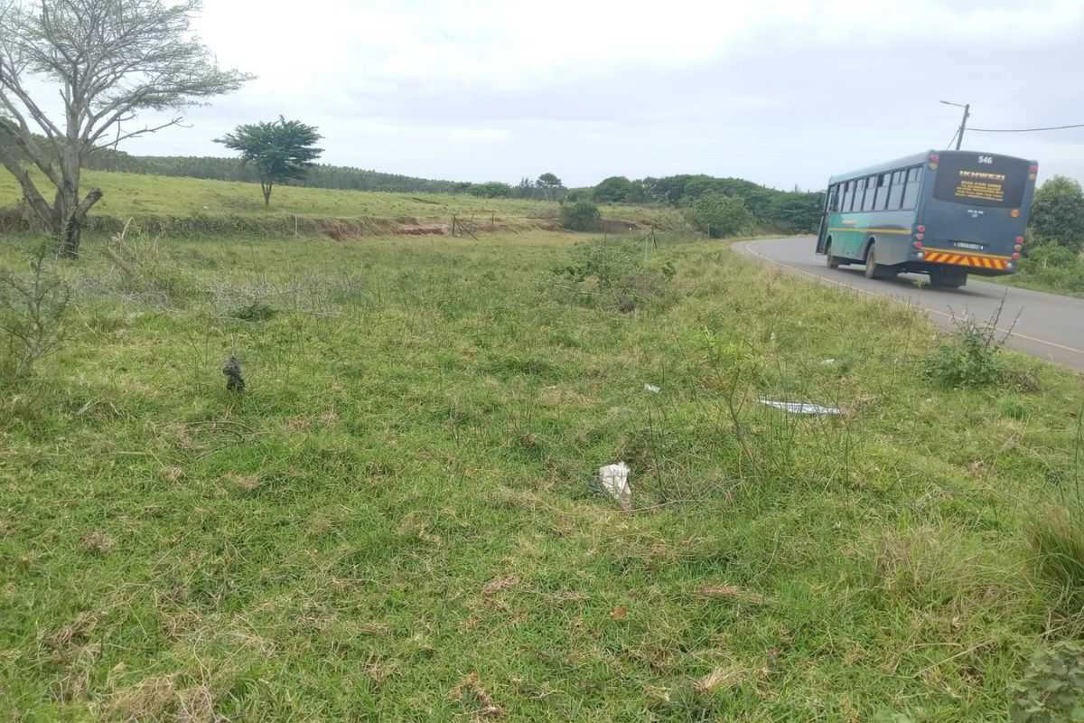 A view of the vacant residential land parcel adjacent to a public road with established grass cover and perimeter fencing.