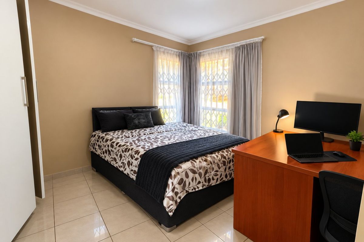 A well-maintained bedroom featuring tiled flooring, built-in wardrobe storage, and security bars on the windows.