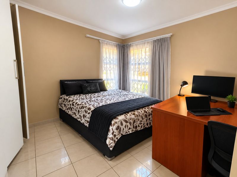 A well-maintained bedroom featuring tiled flooring, built-in wardrobe storage, and security bars on the windows.