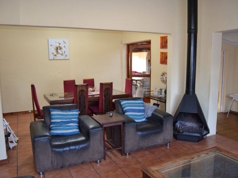 Open plan living and dining area featuring ceramic floor tiles and a prominent black freestanding fireplace.