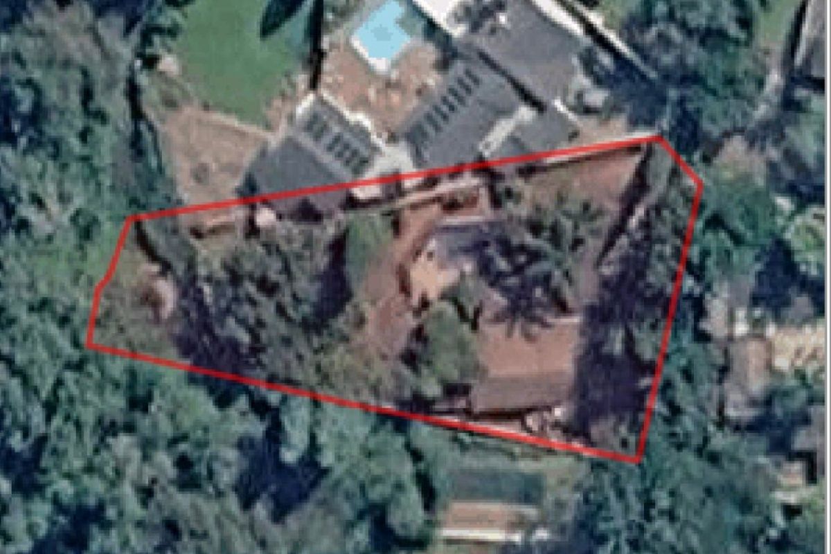An aerial satellite view of the property showing the building footprint, swimming pool, and surrounding garden area within the highlighted boundary.