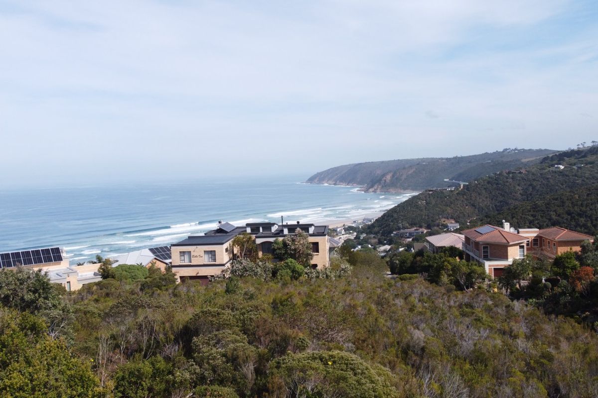 A scenic elevated view overlooking the coastline, ocean, and surrounding residential properties.