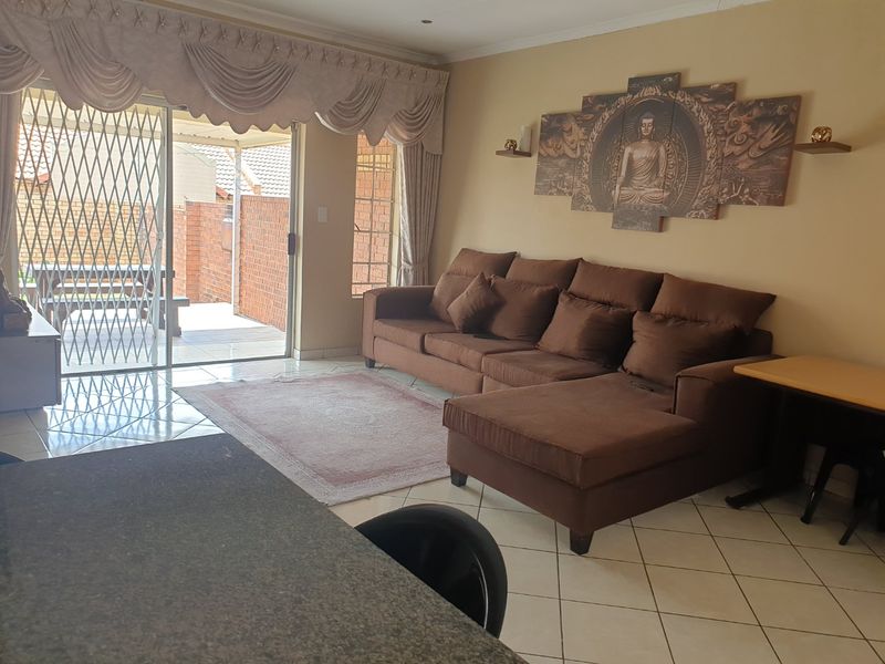 Open plan living area featuring tiled flooring, granite countertop, and sliding glass doors leading to an outdoor patio area.