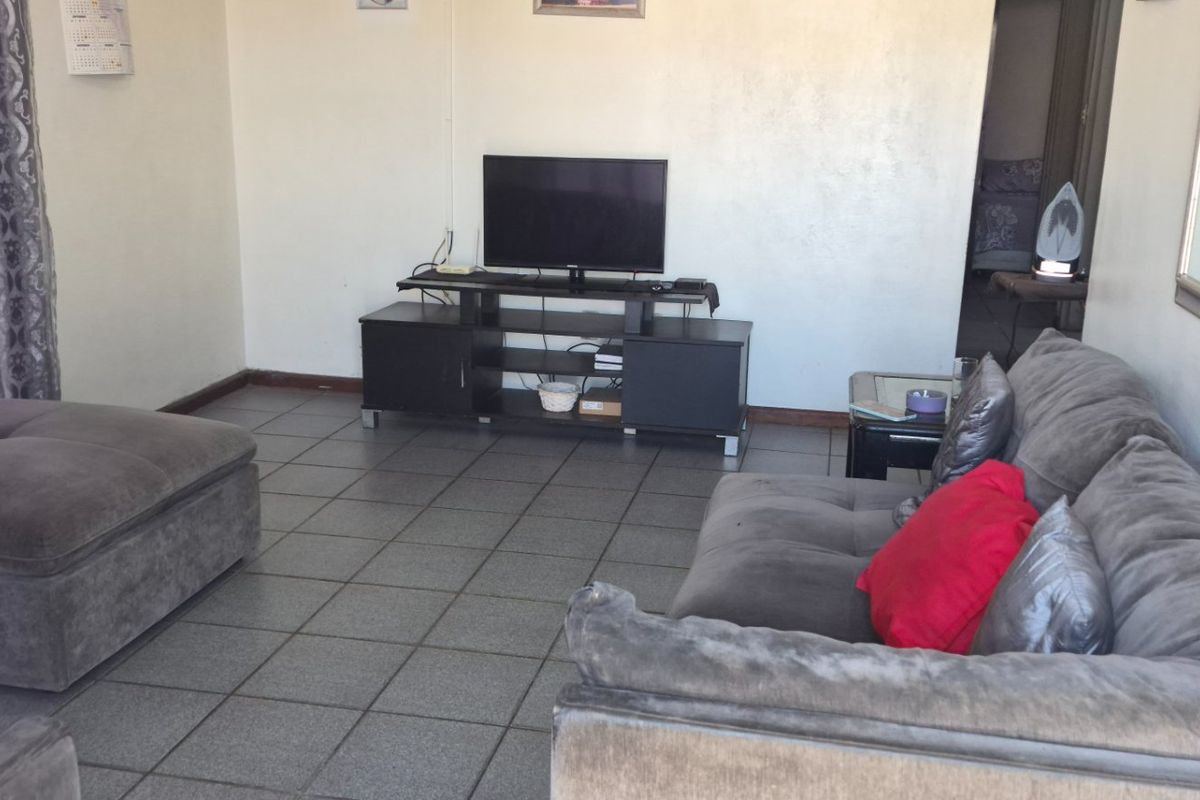 A living room featuring tiled flooring and neutral wall finishes, providing a functional and open space for relaxation.