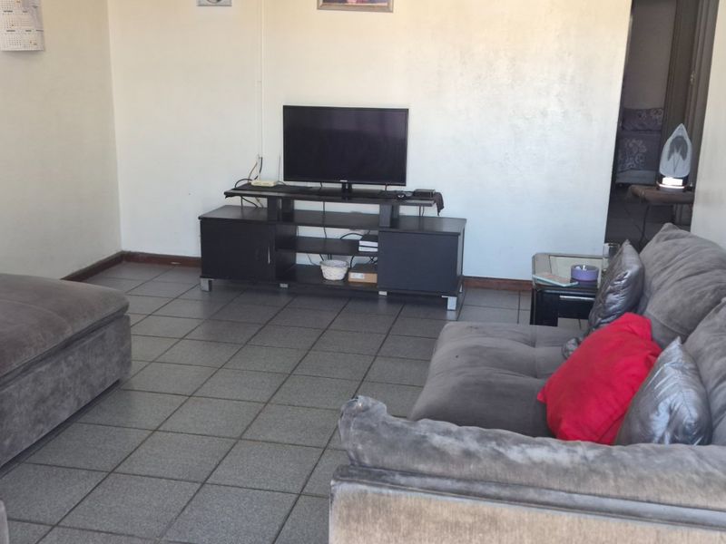 A living room featuring tiled flooring and neutral wall finishes, providing a functional and open space for relaxation.