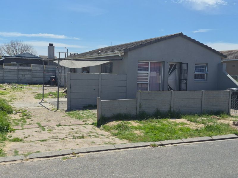 Front view of a detached house featuring a paved driveway, precast concrete boundary walls, and a tiled roof structure.