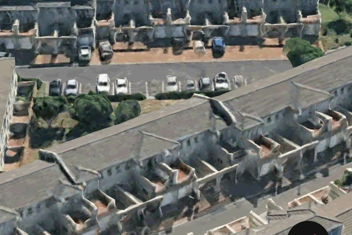 An aerial view of a residential townhouse complex featuring multiple units with tiled roofs and dedicated parking areas.
