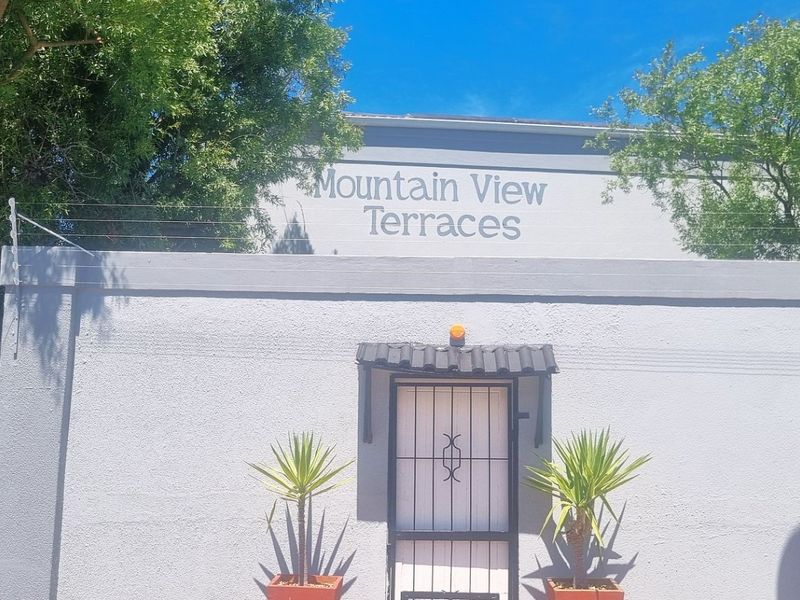 Front entrance view of Mountain View Terraces featuring a secure gate, electric fencing, and communal post boxes.