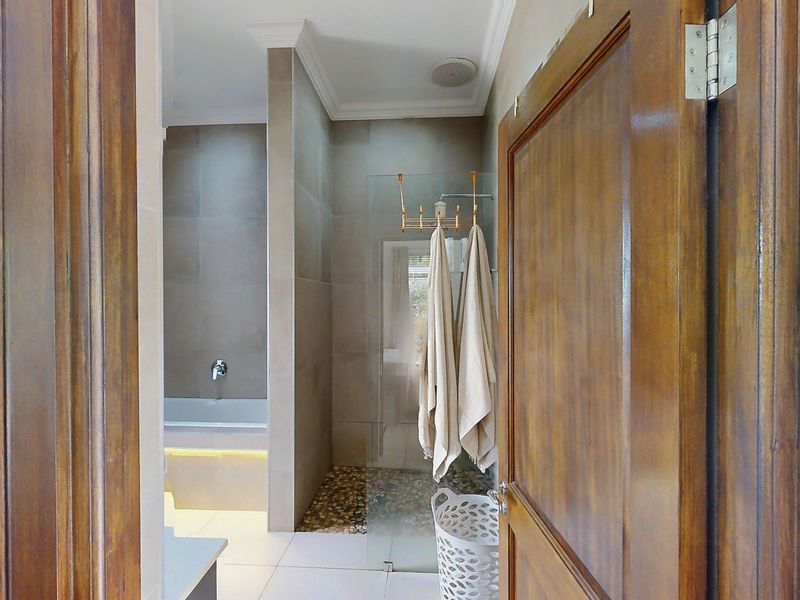 Modern bathroom featuring a built-in bathtub and a separate walk-in shower with a pebble floor finish and glass enclosure.