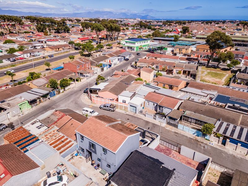 Aerial view of the property and surrounding residential neighbourhood, showcasing the building's roof structure, driveway, and local street layout.