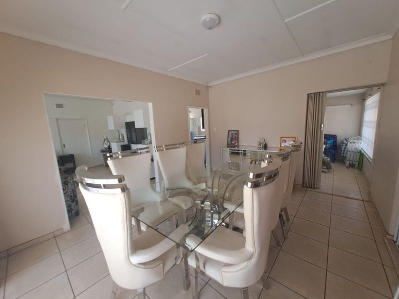 A dining area featuring tiled flooring and a folding door, providing access to adjacent living spaces.