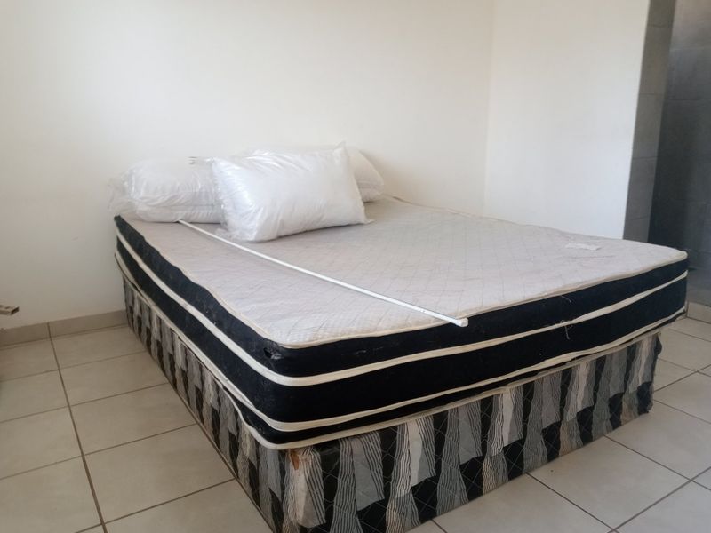 A simple bedroom featuring tiled flooring and neutral wall finishes, providing a blank canvas for potential interior design updates.