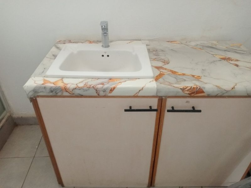 A bathroom vanity featuring a marble-effect countertop with an integrated sink and storage cabinetry.