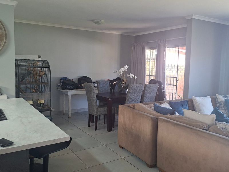 Spacious open-plan living and dining area featuring a modern kitchen island with a built-in gas hob and direct access to the outdoor patio.