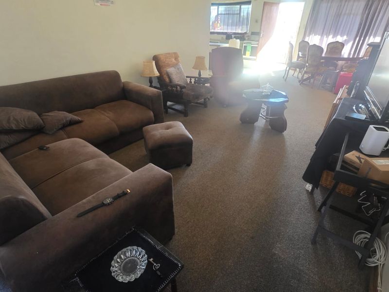 Open plan living and dining area featuring fitted carpeting and access to an outdoor space through a sliding door.