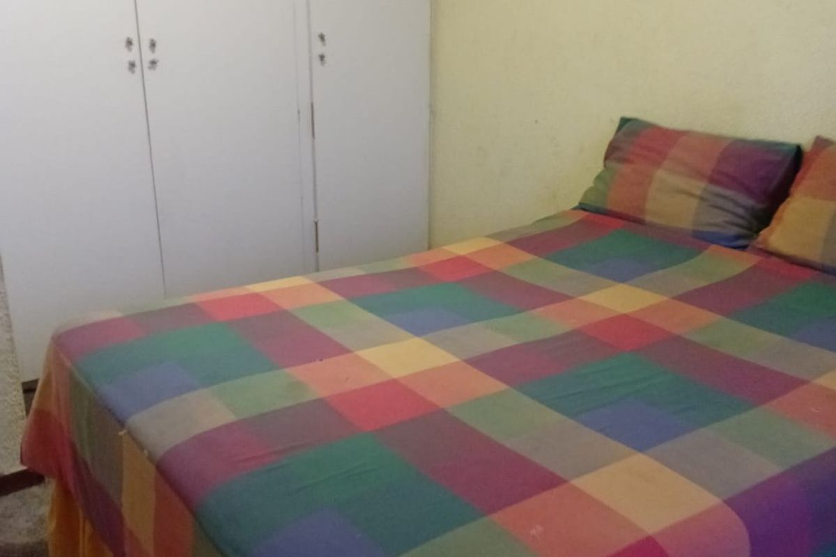 A bedroom featuring built-in cupboards and carpeted flooring, requiring cosmetic updates to the wall finishes.