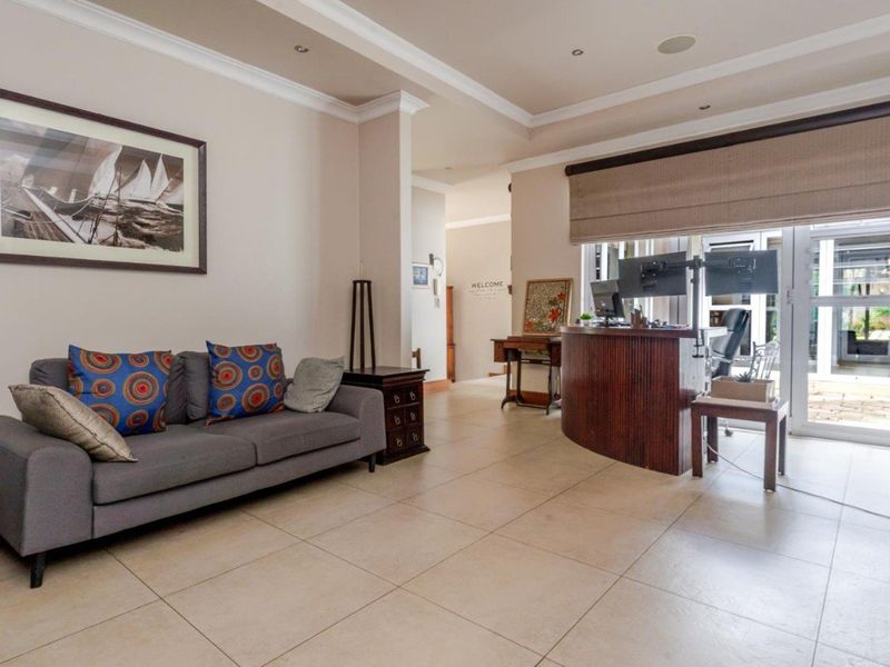 A spacious living area featuring neutral tiled flooring, recessed lighting, and large sliding glass doors that provide access to the exterior.
