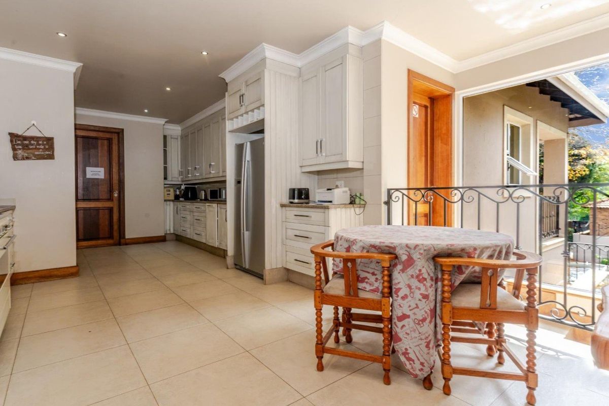 A well-maintained kitchen featuring classic cabinetry, tiled flooring, and recessed lighting, with an open transition to an adjacent balcony area.
