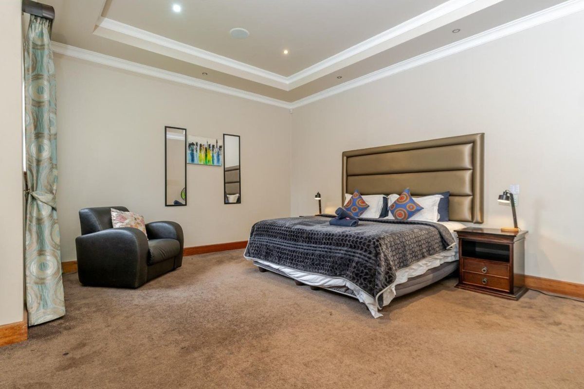 Spacious bedroom featuring a tray ceiling with recessed lighting and neutral wall finishes, providing a comfortable and well-maintained living space.