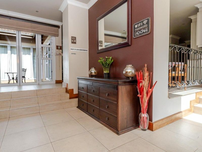 Welcoming entrance hall featuring tiled flooring, coved ceilings, and a wrought iron balustrade leading to adjacent living spaces.