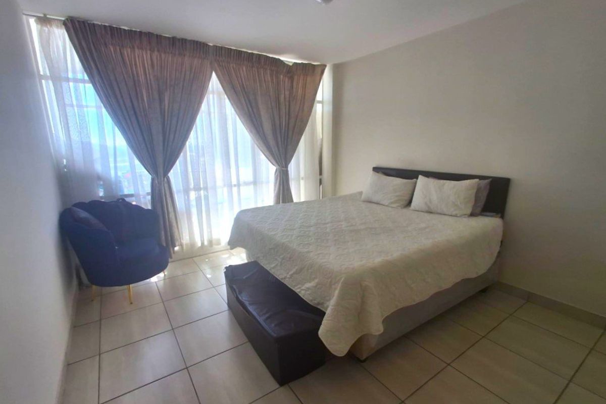 A bedroom featuring tiled flooring and a large floor-to-ceiling window that allows for ample natural light.
