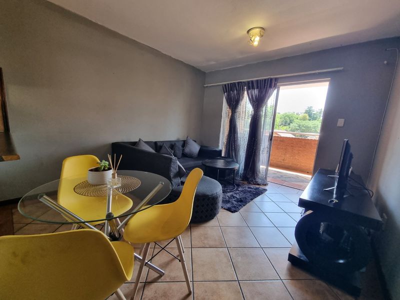 Open plan living and dining area featuring tiled flooring and a sliding glass door leading to an outdoor balcony.