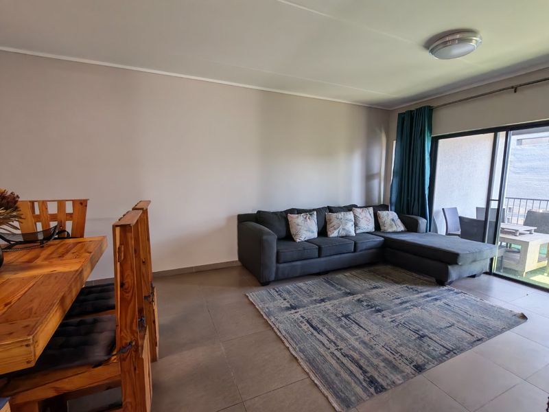Open plan living and dining area featuring tiled flooring and large sliding glass doors providing access to the balcony.