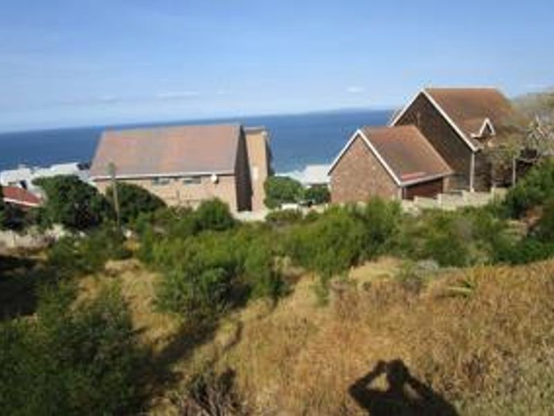 A view of the vacant residential land with surrounding coastal properties and ocean backdrop.