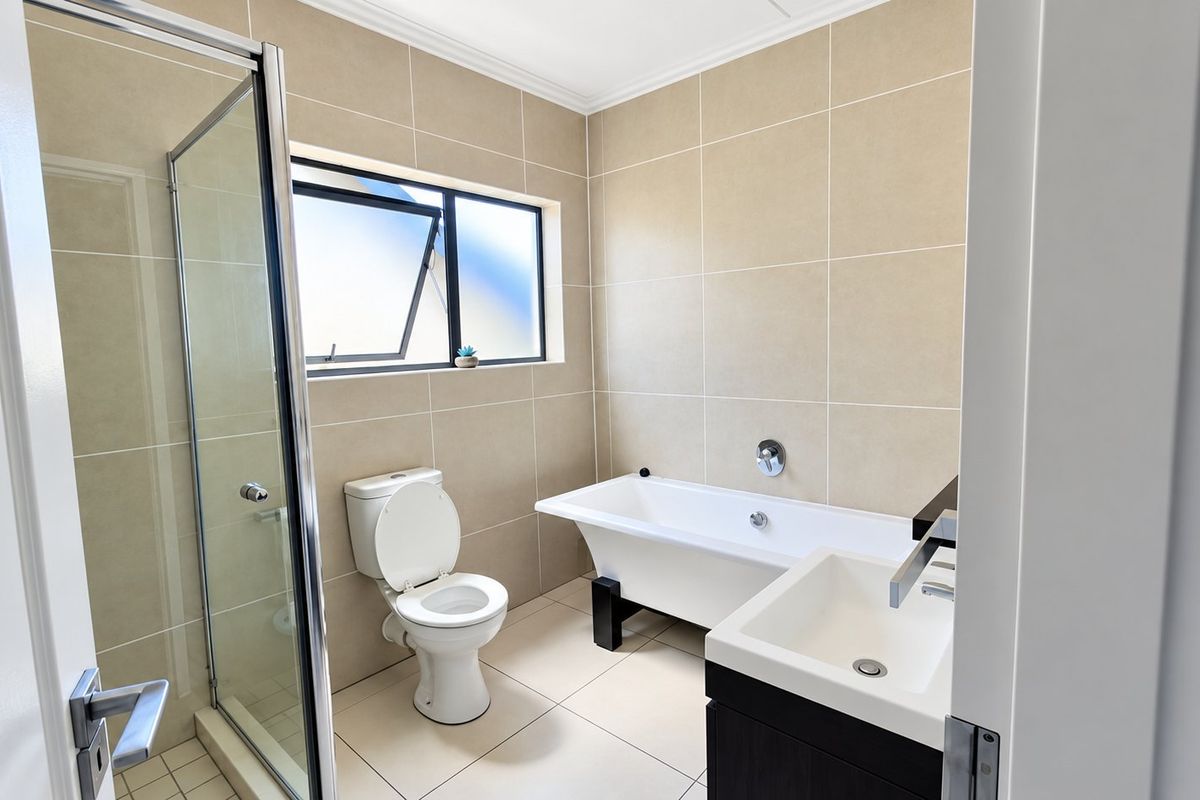 Modern bathroom featuring a freestanding bathtub, separate shower enclosure, vanity basin, and neutral floor-to-ceiling wall tiling.