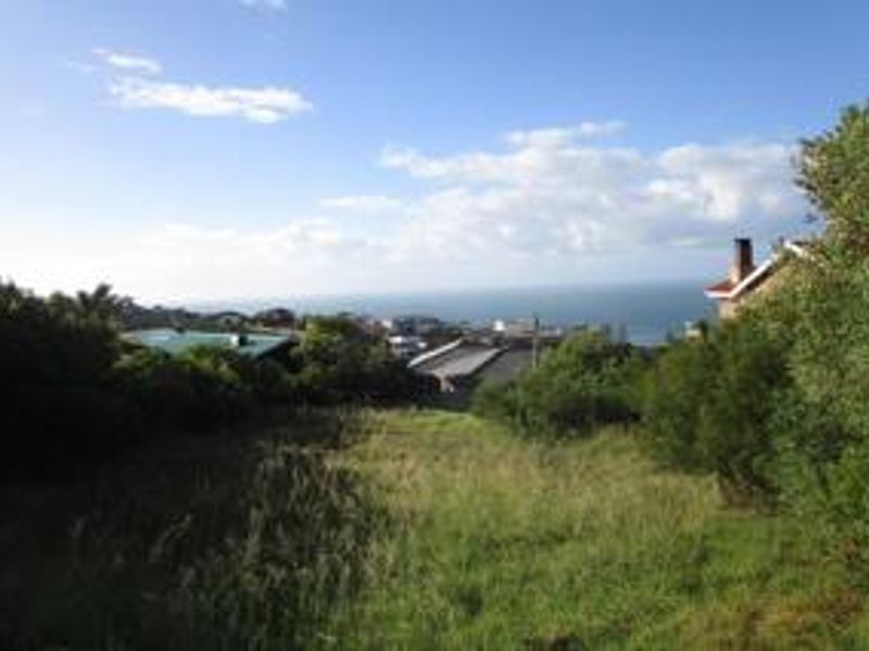 A view of the vacant residential land featuring a sloped grassy plot with a scenic coastal outlook in the background.