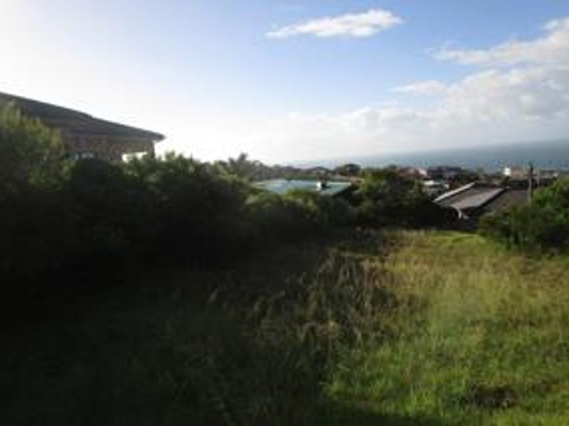 A view of the vacant residential land showing the sloping terrain and surrounding coastal landscape.