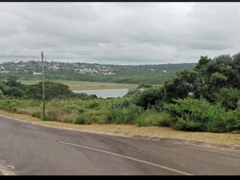 A view of the surrounding landscape and water body from the paved road adjacent to the vacant residential land.