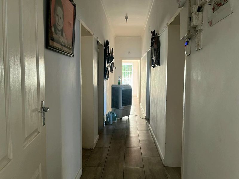 A functional hallway featuring tiled flooring and access to multiple rooms, providing a clean and neutral transition space within the home.